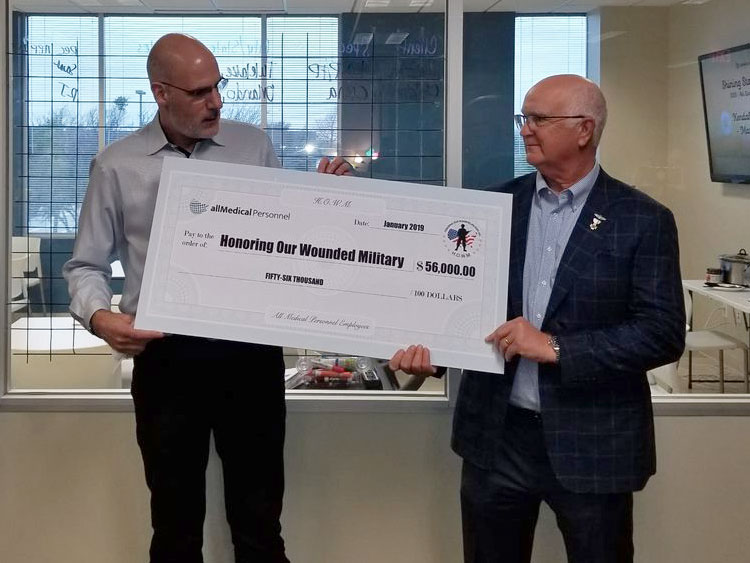 CEO of All Medical Personnel presents a charity check to H.O.W.M.