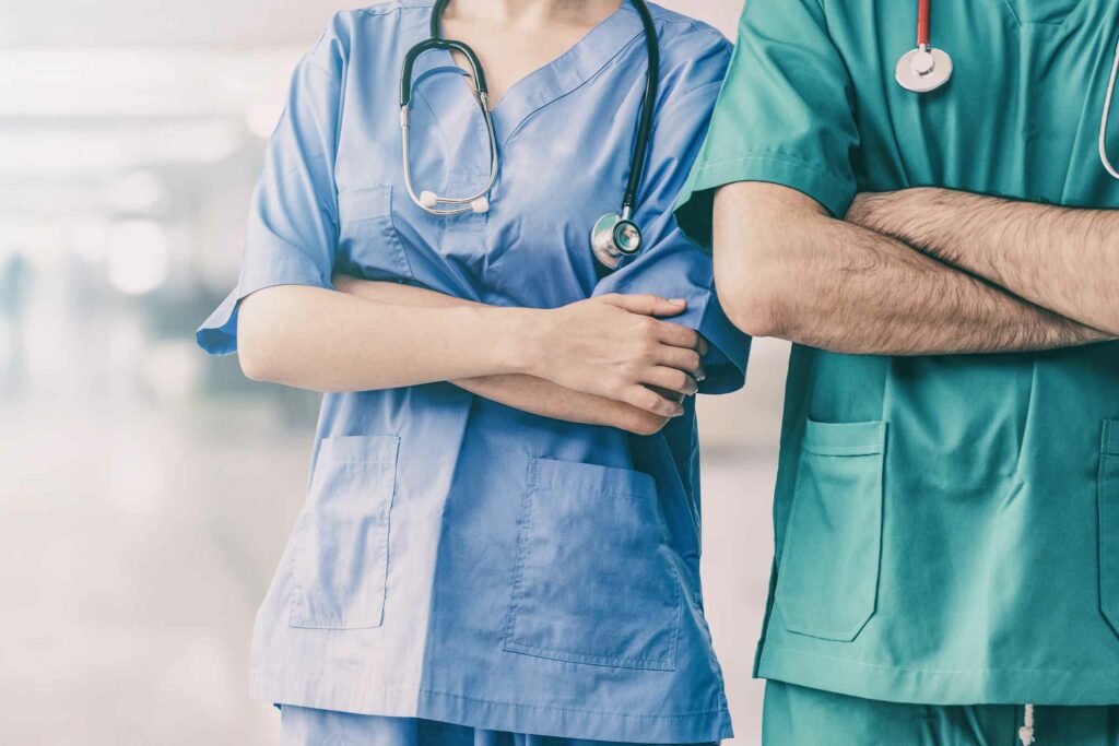 Surgeon and nurse standing in an employer corridor.